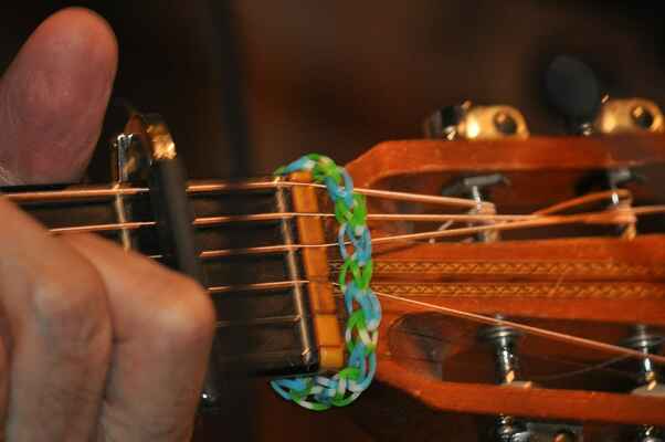 Jeden z mnoha Radkových zlepšováků - jelikož jde s dobou, opatřil kytaře módní gumičkový náramek (umí ztišit struny, když Radek potřebuje).