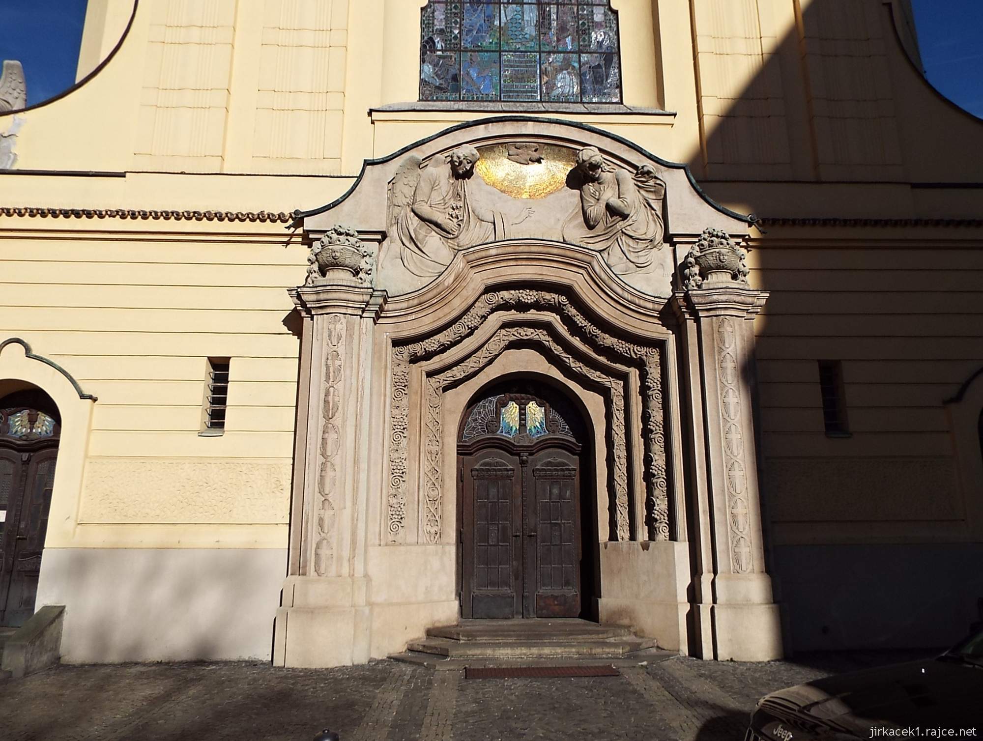 B - Brno - Kostel Neposkvrněného početí Panny Marie 05 - portál z umělého kamene s reliéfem zvěstování Panny Marie a holubicí